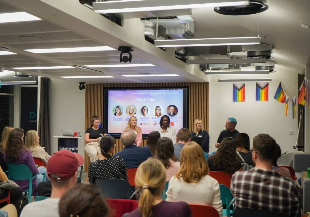 Seven people in an office listening at a community event